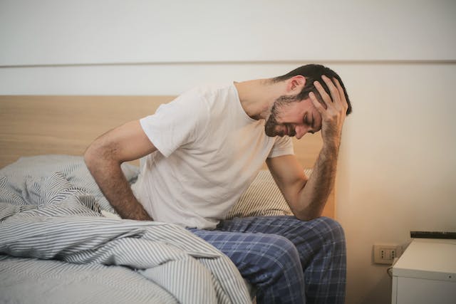 Man waking up with chronic back and head pain