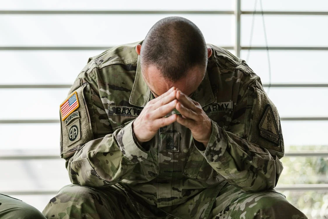 One of the veterans facing chronic pain with his head in his hands