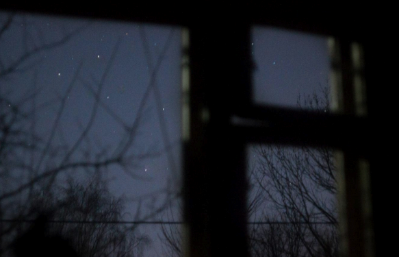 The night sky seen through a window.
