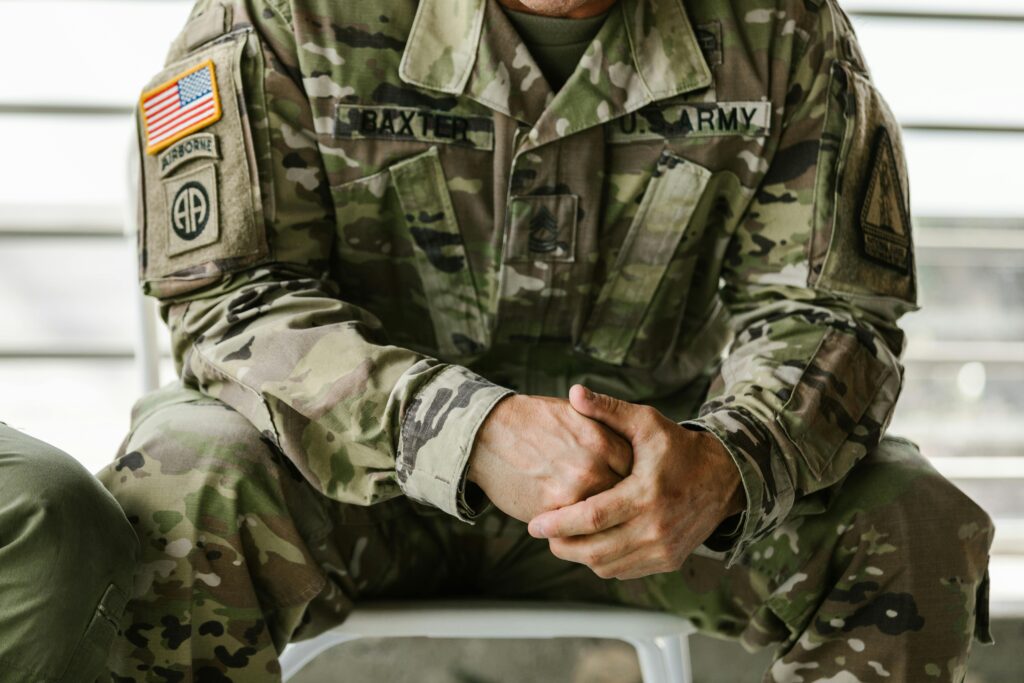 A man in a military uniform sitting solemnly.