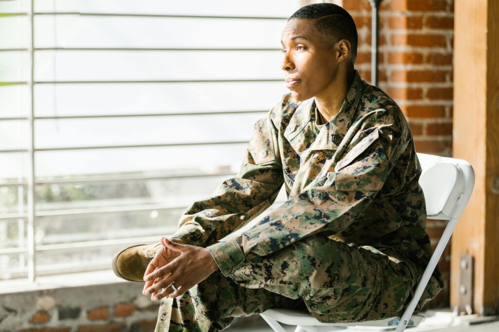 A black woman in a military uniform, looking out of a window.